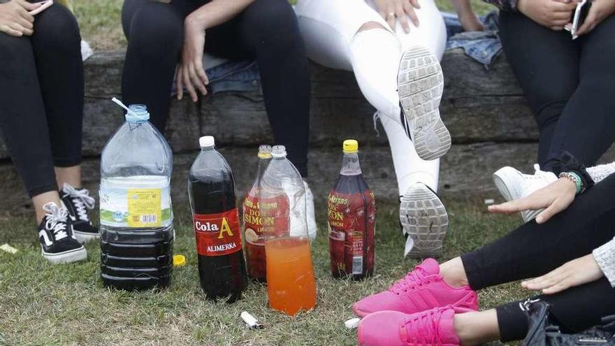 Varias menores, ante botellas de refrescos y alcohol, ayer en un &quot;botellón&quot; con motivo de las fiestas de Montecerrao, en Oviedo.