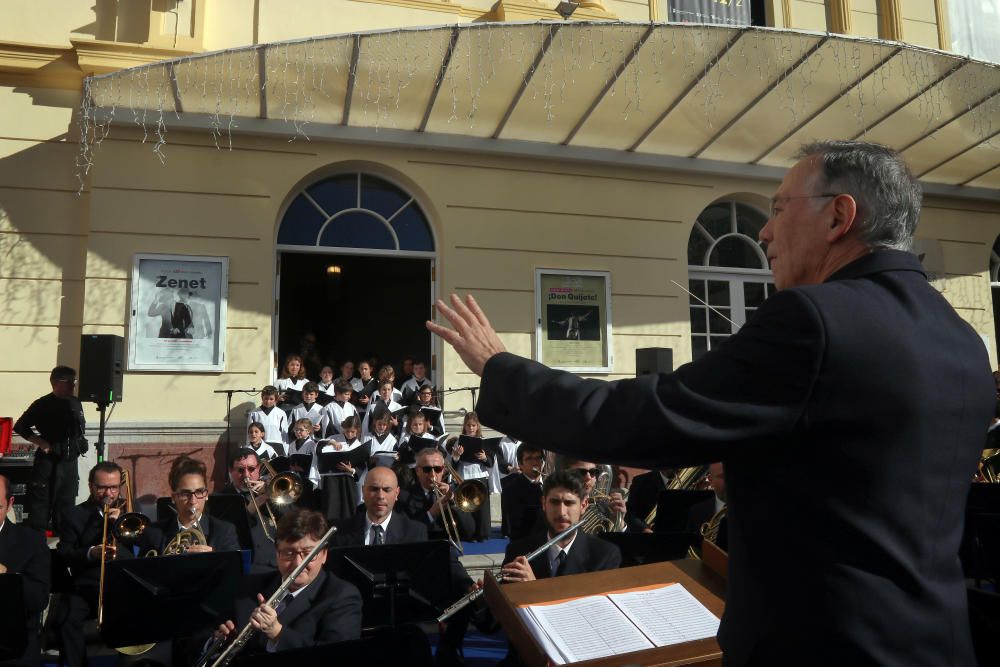 Mil niños de la Fundación Victoria, la Banda Municipal de Málaga y la Escolanía del Corpus Christi ofrecen un concierto navideño frente al teatro malagueño.