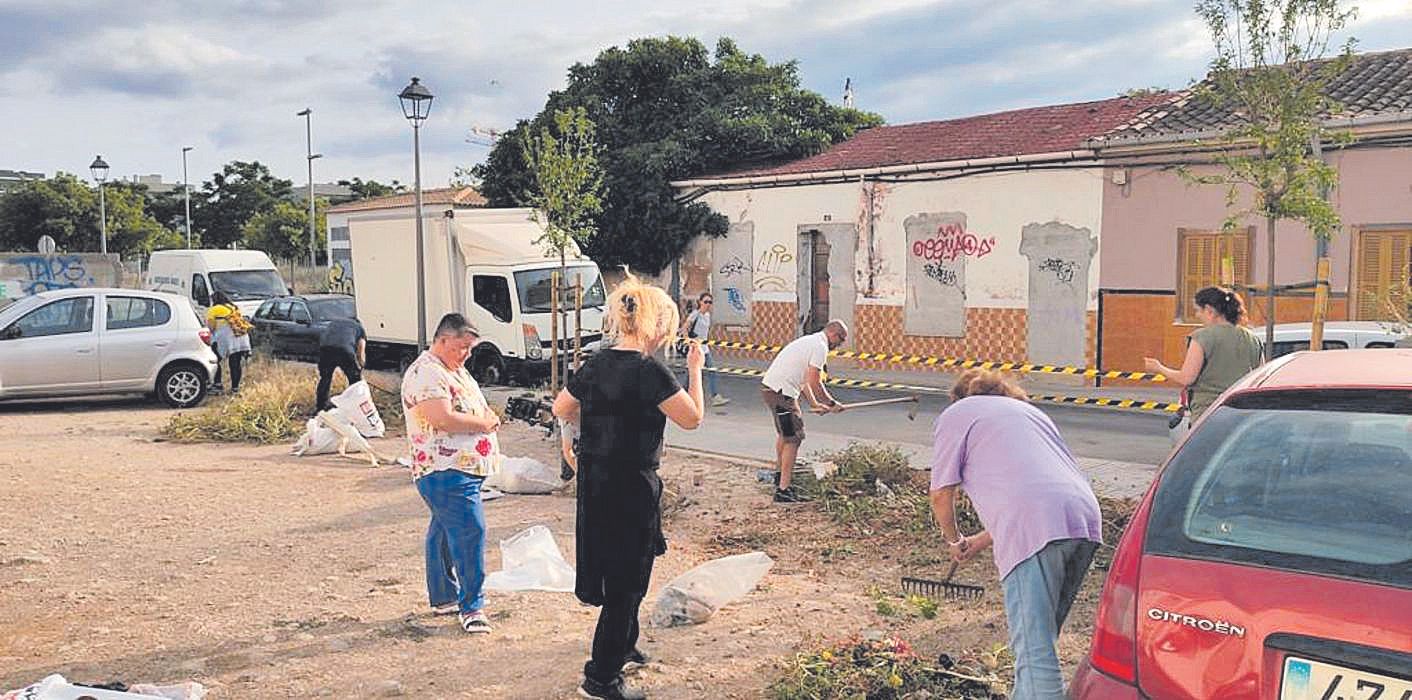 Vecinos limpiando el espacio que dejará de ser para los coches y recuperarán las personas.