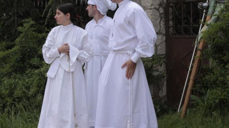 Tres jóvenes de Villarrín esperan antes de salir en procesión.