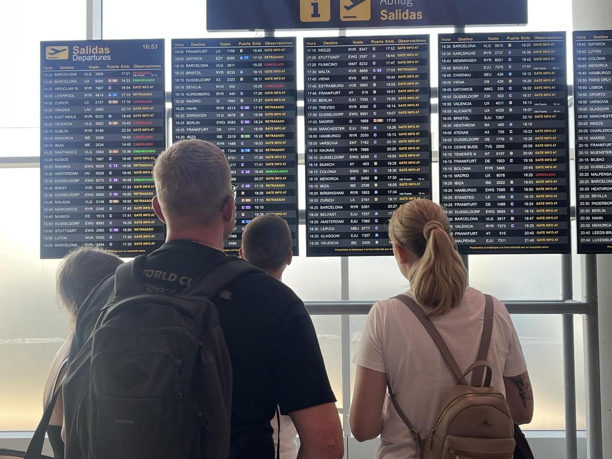 Turistas, hoy, esperando que salga su vuelo en el panel de Son Sant Joan, en Palma.