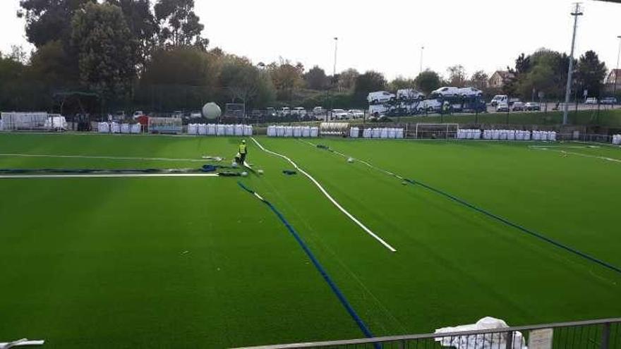 Operarios municipales trabajando en el campo de fútbol de Navia. // FdV