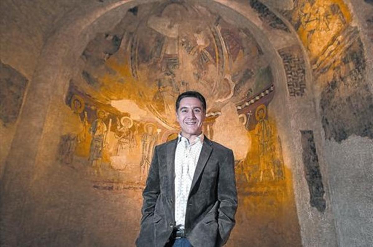 Martí Gironell, al costat d’una de les pintures murals que conserva el MNAC, durantla presentació de ’Strappo’.