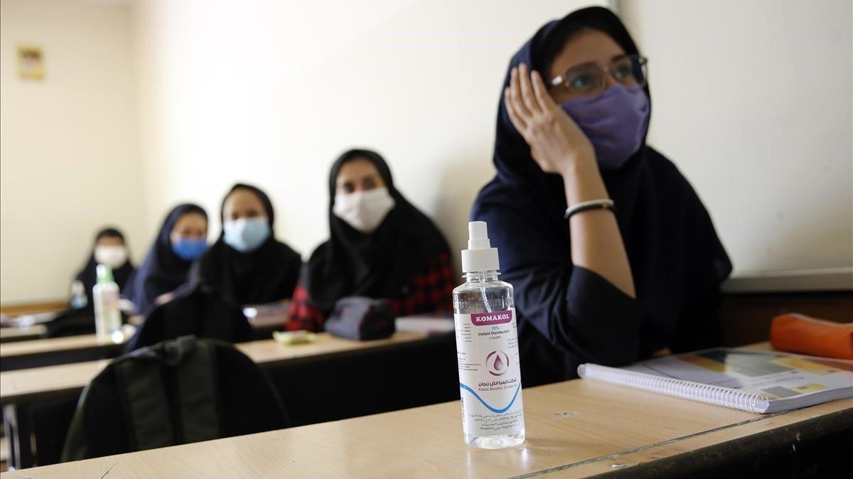 Niñas de secundaria iraníes con máscaras faciales asisten a una clase en la escuela privada Bamdad Parsi, durante el primer día de reapertura de las escuelas al norte de Teherán, Irán.