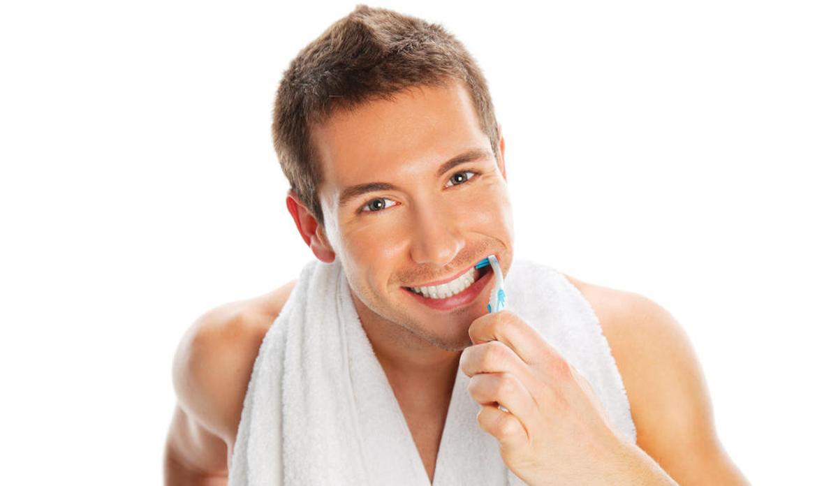 Un hombre se cepilla los dientes.