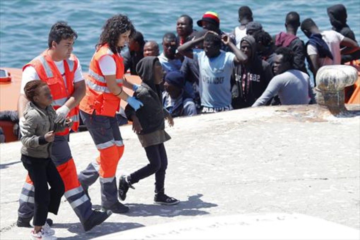 Miembros de la Cruz Roja acompañan a unos menores inmigrantes a su llegada a Tarifa.