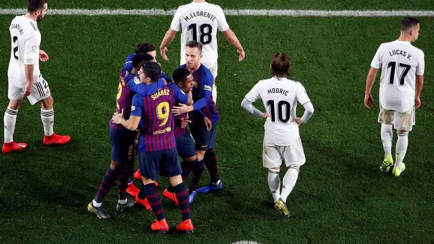 Los jugadores del Barcelona celebran el gol de Malcolm rodeados de madridistas. // Efe