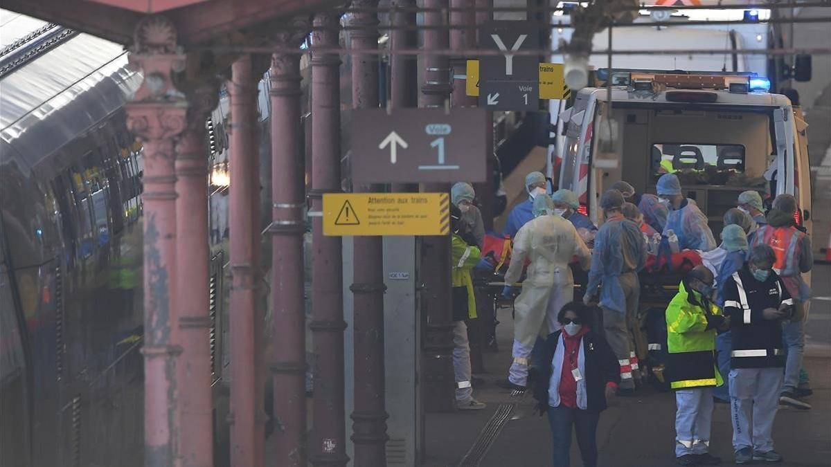 Personal médico introduce a un paciente en el tren en la estación de Estrasburgo, en Francia.