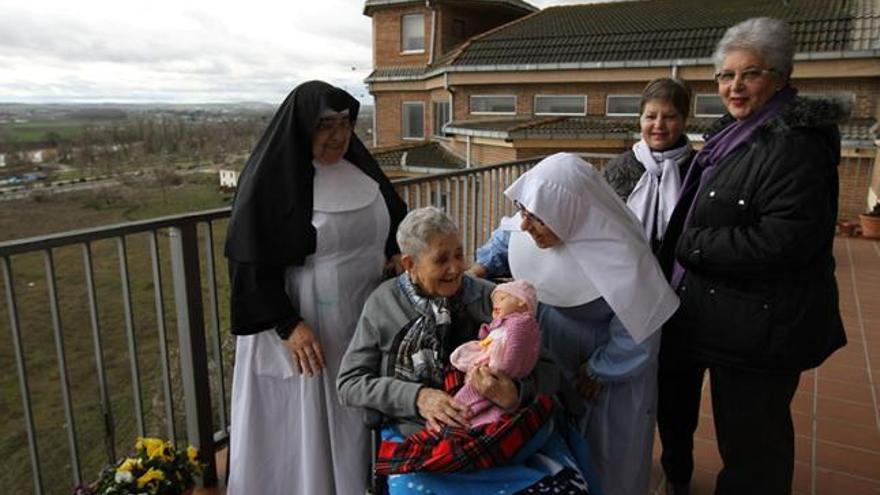 Flora Álvarez Temprano, en el centro, rodeada de toda su familia en la iglesia de la residencia Reina de la Paz, donde vive desde hace trece años.