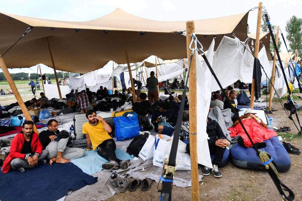 Mujeres y niños entran dentro del centro a esperar su proceso de registro, pero los hombres, de diferentes edades, aguardan hacinados y tumbados en el suelo.