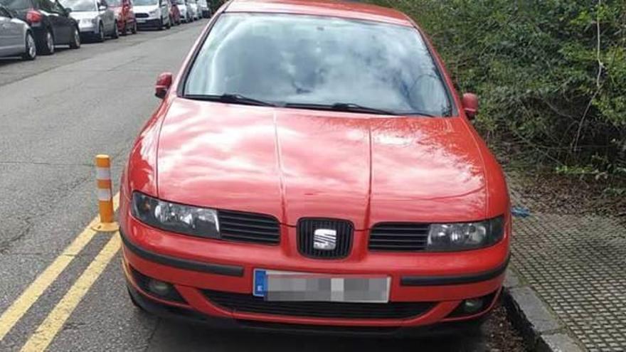 Un coche aparcado en el carril peatonal de la parcela del viejo hospital.