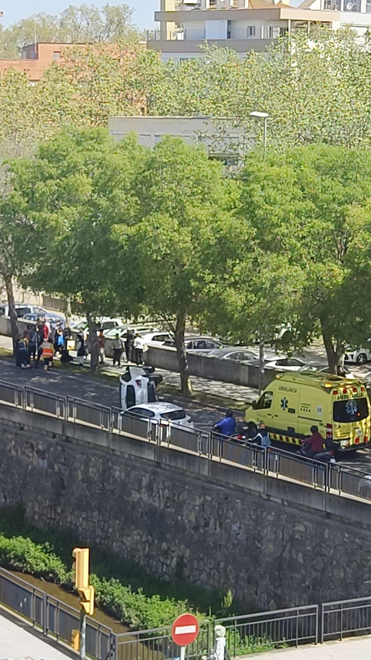 El vehicle bolcat i els serveis d'emergència a l'avinguda Josep Tarradellas de Girona.