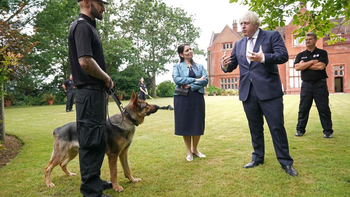 Boris Johnson y la secretaria de Vivienda, Priti Patel, departen con un agente durante una visita a la comisaría de la policía de Surrey en Guildford el pasado 27 de julio.