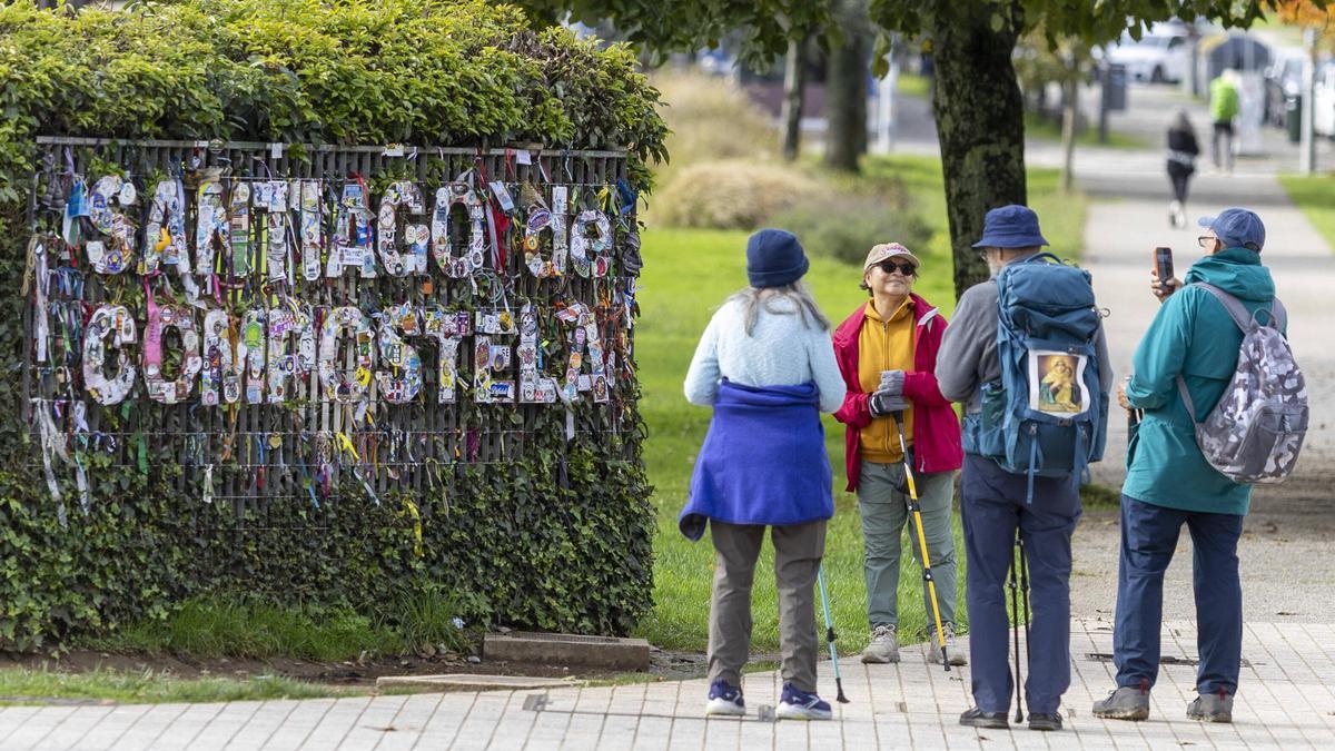 Un grupo de peregrinos se hace fotos al entrar en Santiago por el Camino Francés
