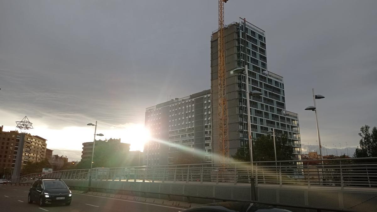 El sol se pone tras el edificio Sky Line, en la plaza Europa, este viernes