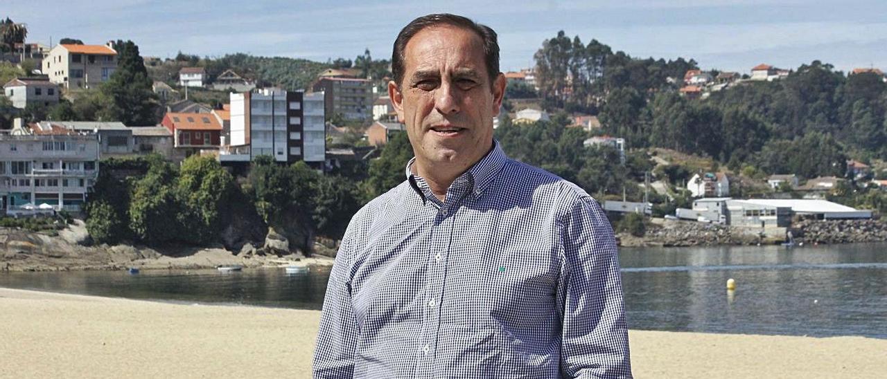 Valeriano Martínez, en Banda do Río, en Bueu, en 2016, con su casa, al fondo por detrás de los edificios . | // G.N.