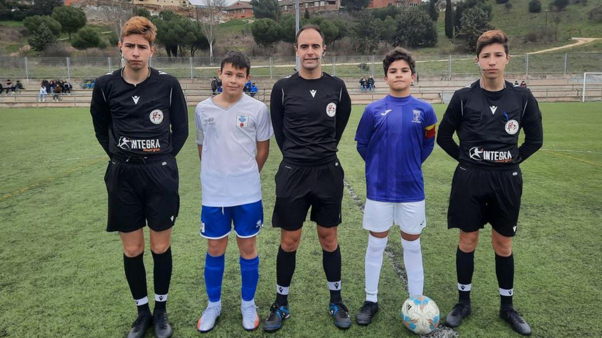 Los capitanes de ambos equipos posan con el trío arbitral.