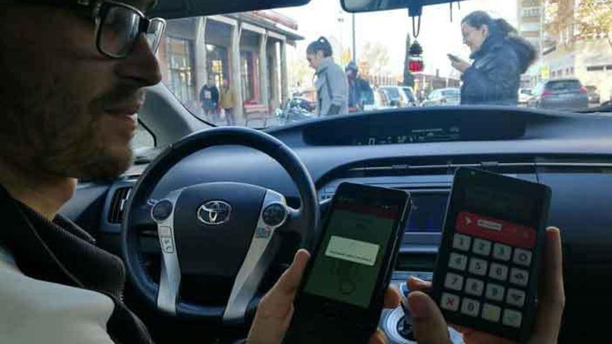 Un joven taxista muestra el equipo telemático para efectuar el abono.