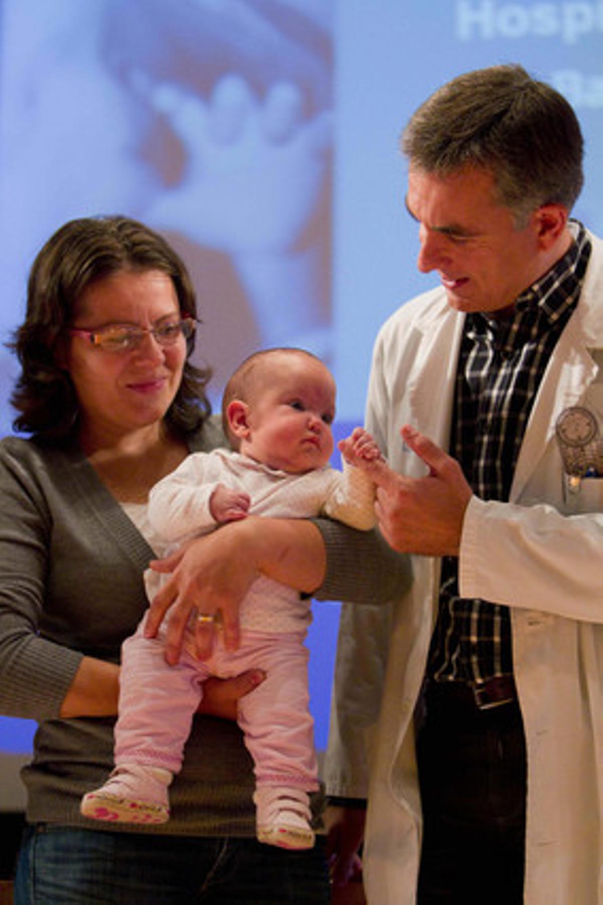El doctor César García juga amb la nena operada, als braços de la seva mare. El doctor César García juga amb la nena operada, als braços de la seva mare.