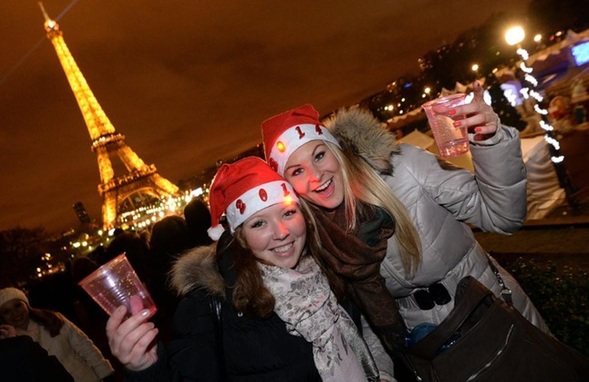 París; dos joves celebren l’any nou a la plaça Trocadero amb la Torre Eiffel de fons.