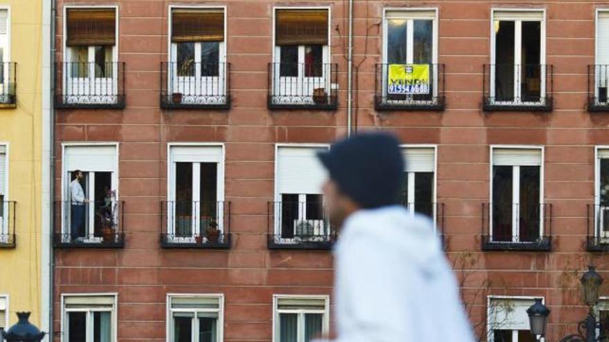 Un paseante camina por delante de un edificio residencial.