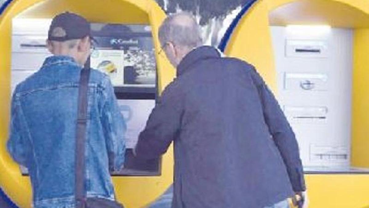 Dos personas sacando dinero de un cajero en Murcia