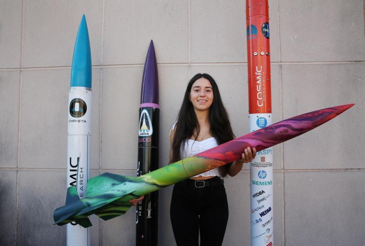 La ingeniera Alba Badia posa junto a varios prototipos de cohete desarrollados por la plataforma Cosmic Research.