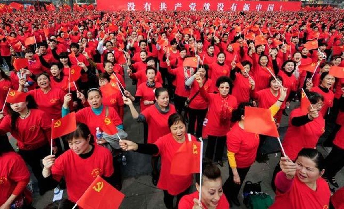 Participants en les celebracions del 90 aniversari del Partit Comunista Xinès canten himnes revolucionaris i fan onejar banderes vermelles en una plaça de Chongqing.
