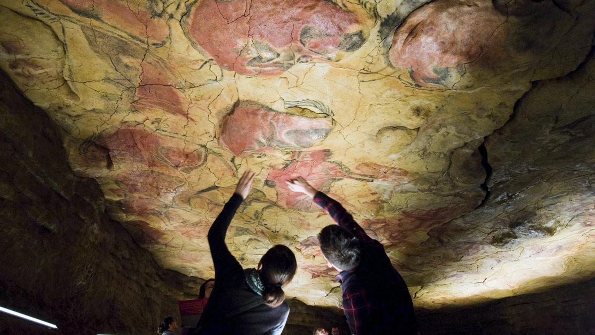 Visitantes observan las pinturas rupestres en el Museo de Altamira, en foto de archivo