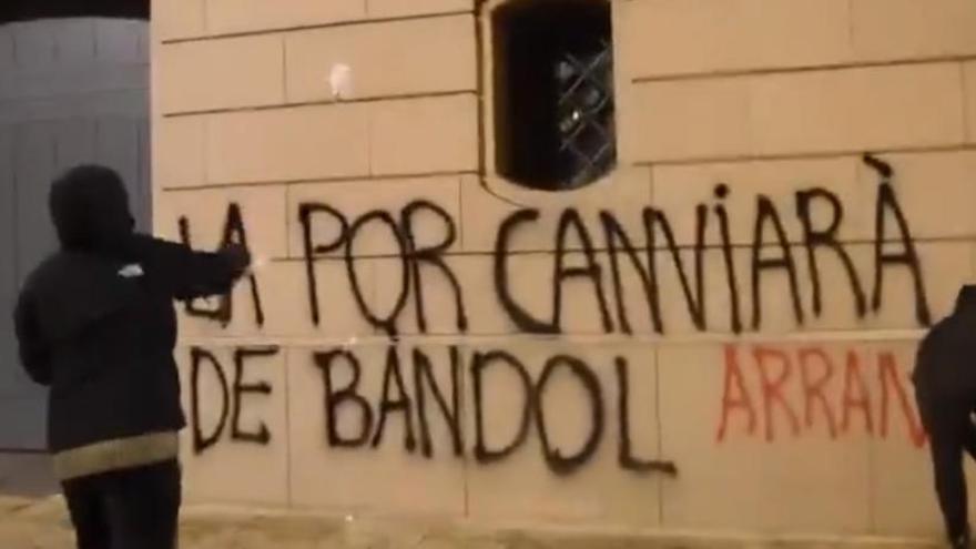 Moment del vídeo publicat per Arran amb dos encaputxats pintant fent les pintades