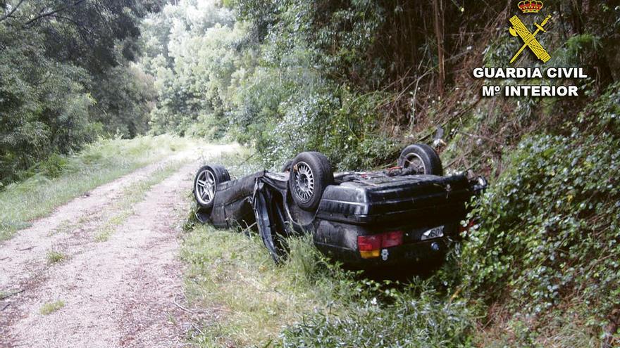 El coche que ocupaban el piloto y el herido grave quedó volcado tras el accidente. // Guardia Civil