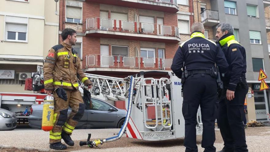 Un bomber i policies, aquest dimecres al matí davant del bloc incendiat