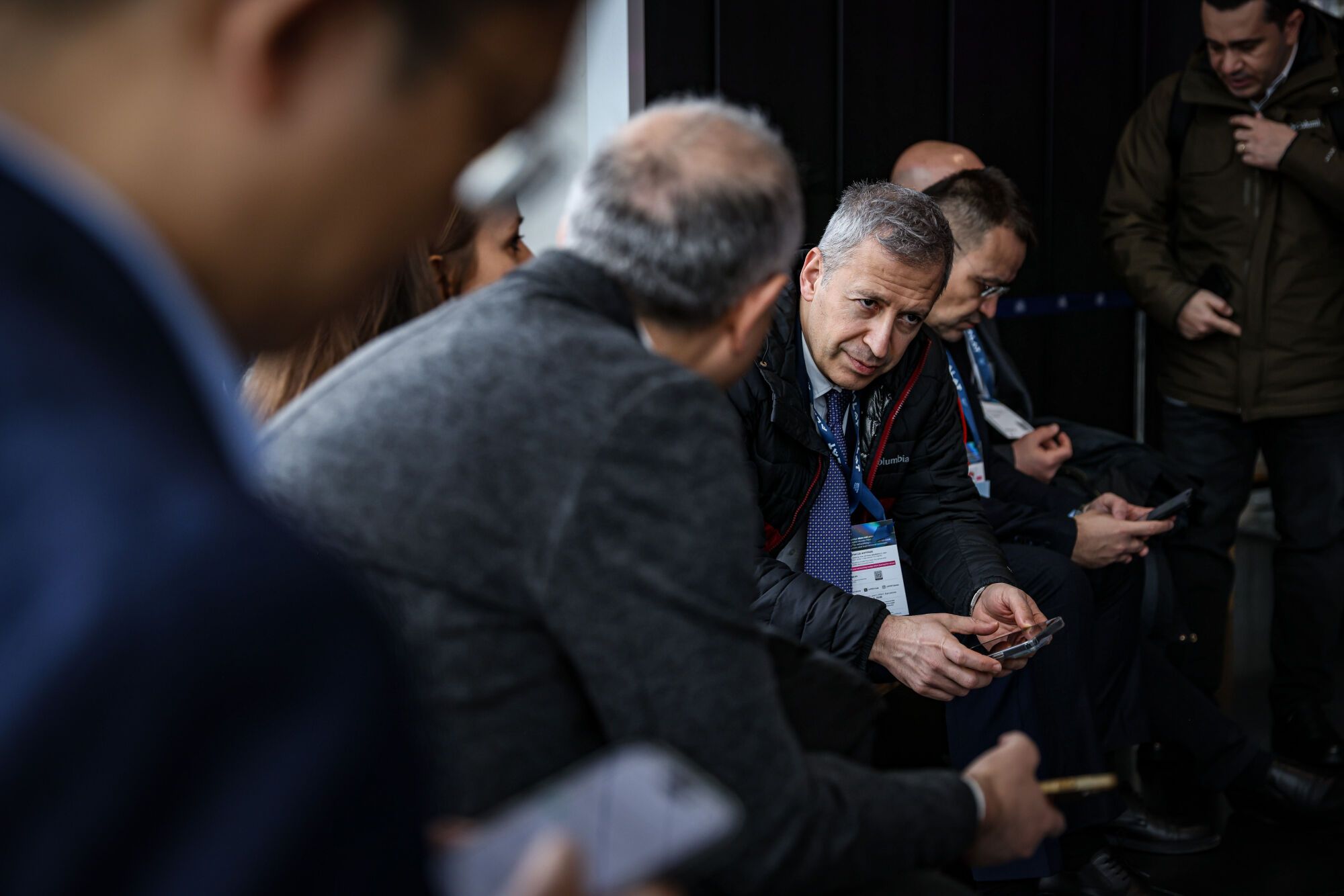 Homes asseguts i conversant als accessos del MWC