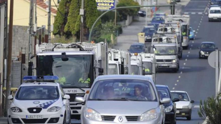 Un coche de la Policía Local escolta a los camiones de Cespa, uno de los primeros días de huelga. / c. pardellas