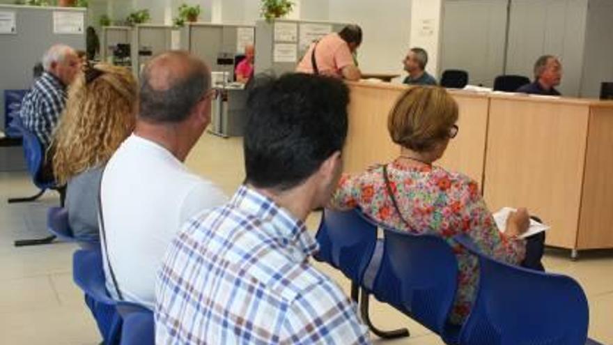 Vecinos, esperando su turno en el registro municipal.