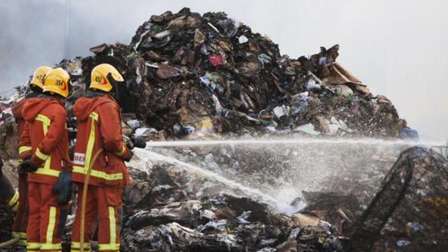 Los bomberos durante la extinción del incendio industrial declarado en Alboraia.