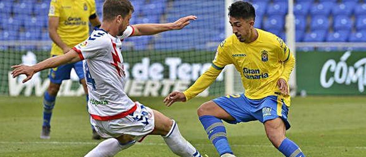 Toni Robaina realiza un quiebro a Ernesto Galán, exfutbolista de la UD Las Palmas, durante la primera parte del partido de ayer en el Gran Canaria.