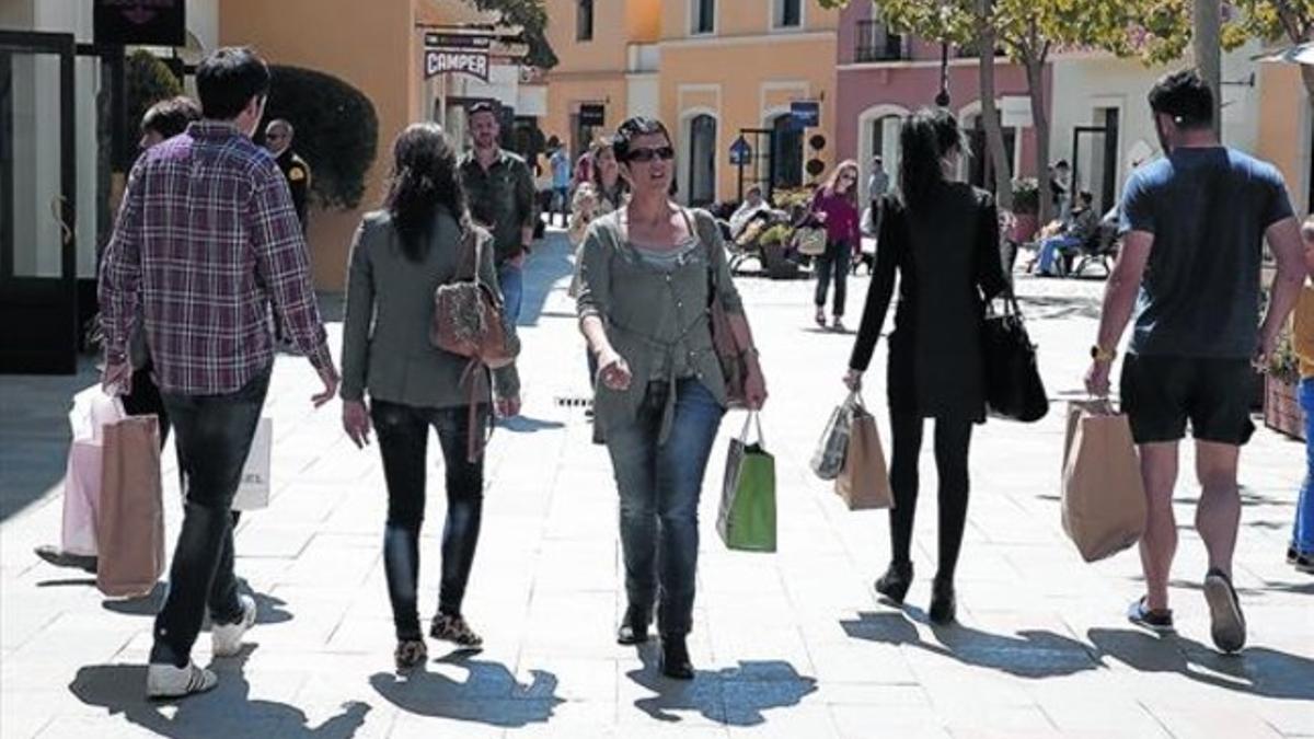 Compradores paseando por las calles de La Roca Village, ayer.