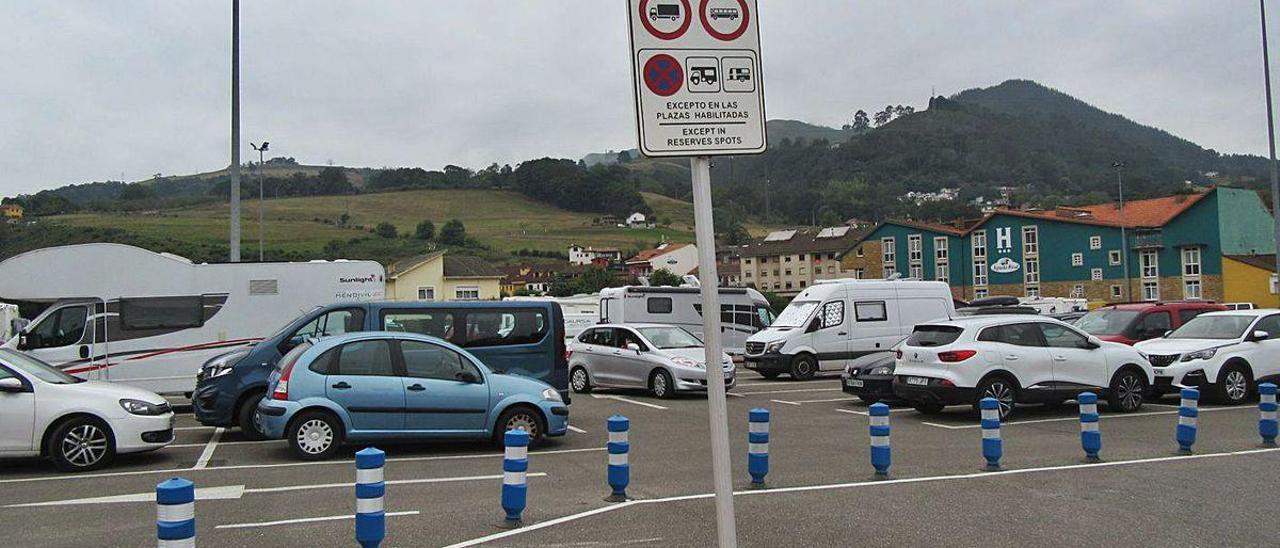 Autocaravanas aparcadas en Cangas de Onís, con un cartel que indica la regulación del estacionamiento.