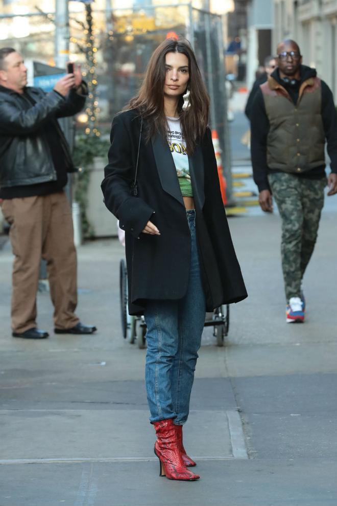 Emily Ratajkowski con blazer negra, jeans y botines rojos