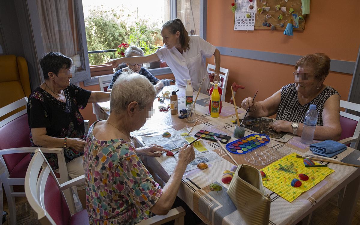 Varios residentes del geriátrico Verdi Residencial, en Barcelona, participan de un taller de pintura.