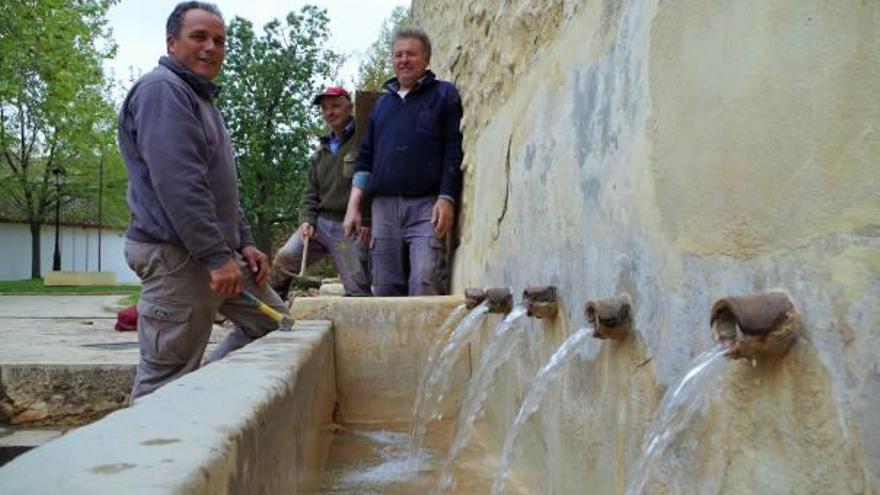 Los operarios de las obras, junto a la Font de Baix plenamente restablecida.