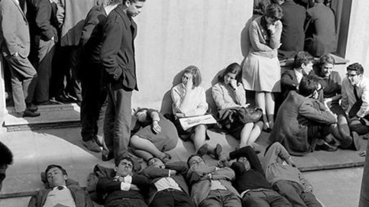 Los estudiantes -ellos, con la corbata pactada- siguieron atentos  la asamblea del 9 de marzo de 1966. En la presidencia, entre otros, Antoni de Moragas y los pintores Antoni Tàpies y Albert Ràfols-Casamada (foto superior, de izquierda a derecha). El