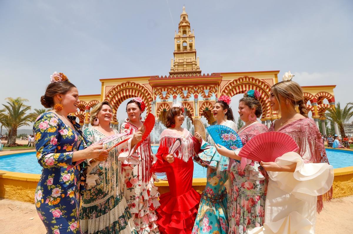 Varias mujeres tratan de refrescarse con sus abanicos a la entrada del recinto ferial.