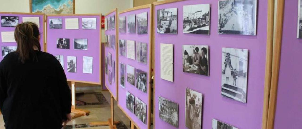 Una joven observa las fotografías expuestas en la Casa de Cultura.