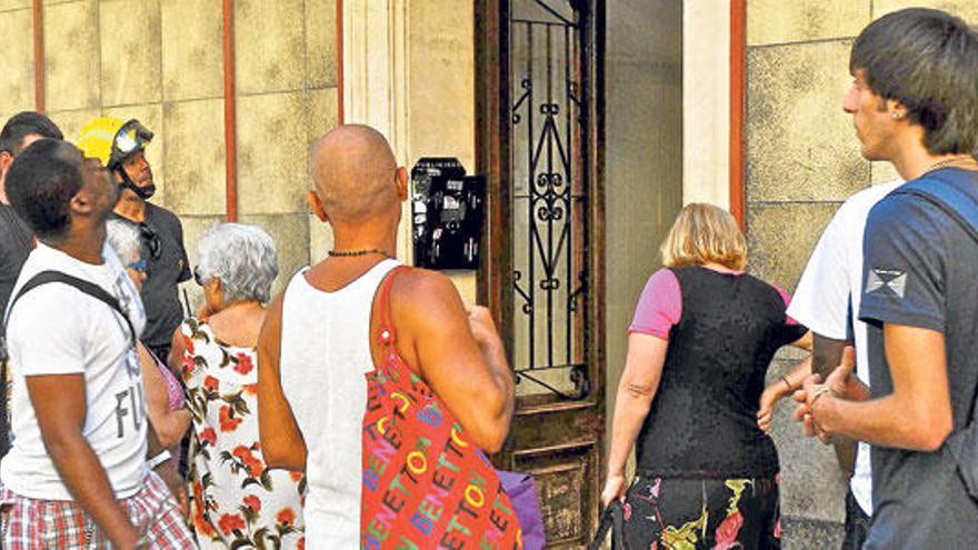 Los propietarios de Pi i Margall, 6, durante la recogida de enseres de primera necesidad de ayer.