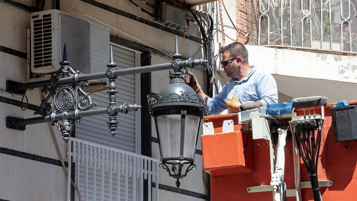 Un operario municipal instala una de las nuevas farolas de estilo clásico en el barrio de San José en Elche