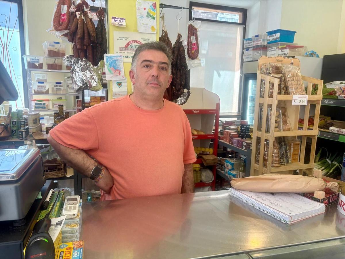 Alfonso Palacio, tras la barra de su negocio, en Sama.