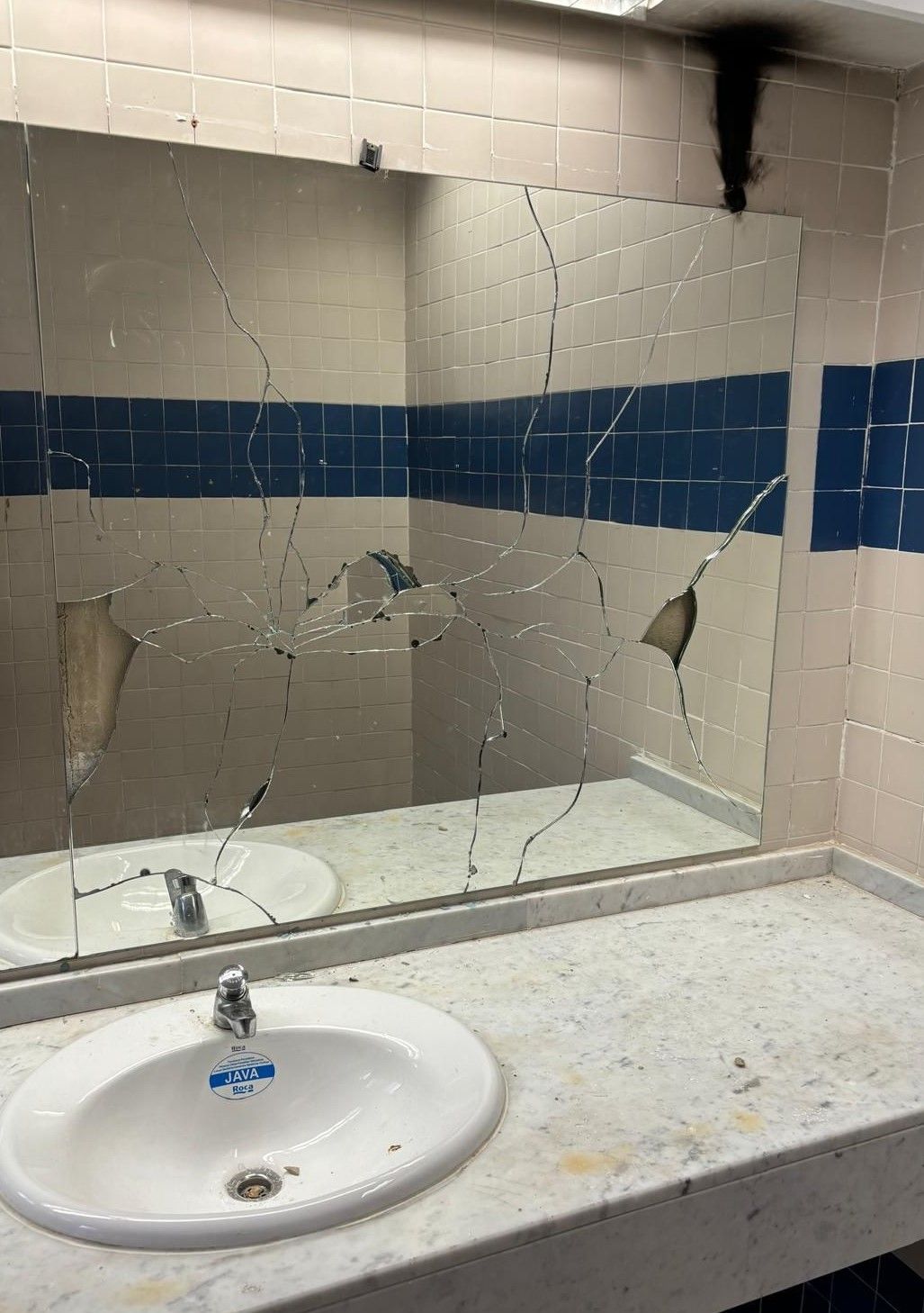 Espejo roto en los baños del polideportivo de Utiel.
