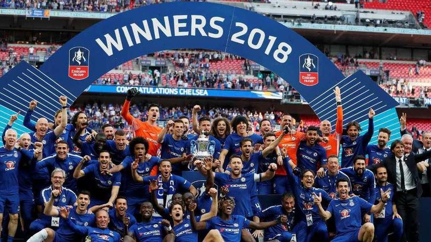 Los futbolistas del Chelsea posan con el trofeo que conquistaron tras vencer al Manchester United.